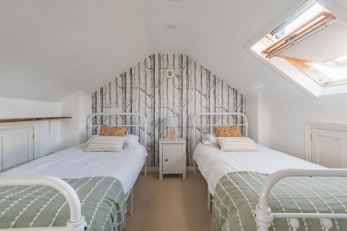 two twin beds in a room with a window at Fern Cottage by Keepers Cottages in Whitstable