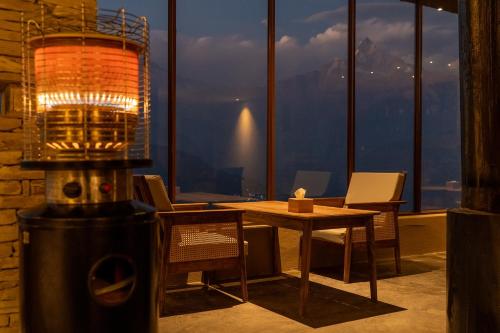 a dining room with a table and a lamp in a room at Nana Mountain Resort in Astam
