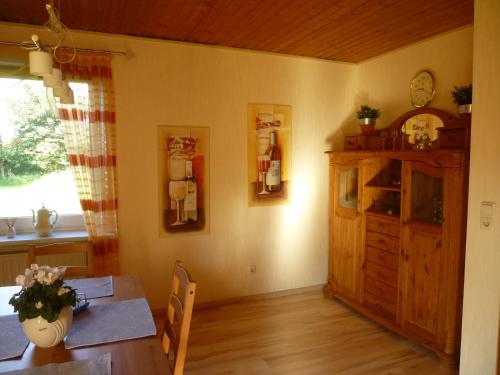 a dining room with a table and a clock on the wall at Ferienwohnung Stoeterau - ebenerdige FeWo mit Sonnenterrasse in Erfde