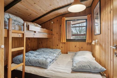 a bedroom with bunk beds in a wooden cabin at Cozy Summer House In Trend in Løgsted