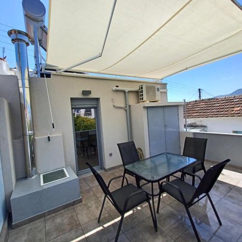 eine Terrasse mit Tisch und Stühlen auf einem Balkon in der Unterkunft Doukas Home in Mytilini