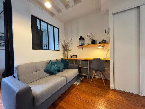 un salon avec un canapé et un bureau dans l'établissement Charmant appartement en centre ville de Fontainebleau, à Fontainebleau