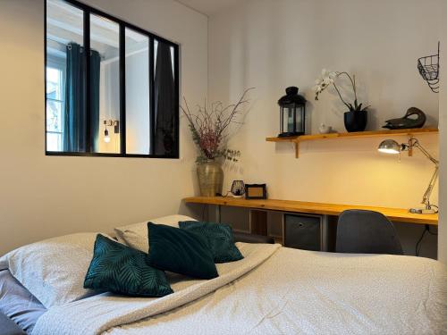 une chambre avec un lit, un bureau et une fenêtre dans l'établissement Charmant appartement en centre ville de Fontainebleau, à Fontainebleau