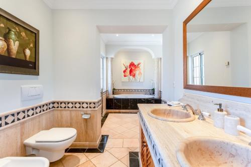Un baño con dos lavabos y un inodoro. en Villa Breena - Quinta do Mar, en Almancil