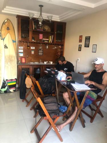 a group of people sitting around a table with a laptop at Felicidade in sea front in Saquarema