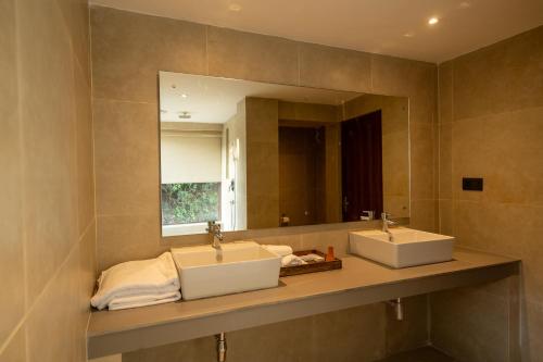 a bathroom with two sinks and a large mirror at Nana Mountain Resort in Astam