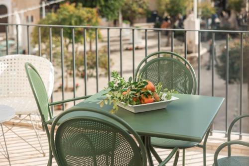 a green table with a bowl of vegetables on it at Palazzo Indelli in Monopoli