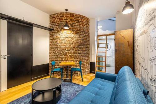 un salon avec un canapé bleu et une table dans l'établissement The Night Beauty - Renovated & Design - Bastille, à Paris