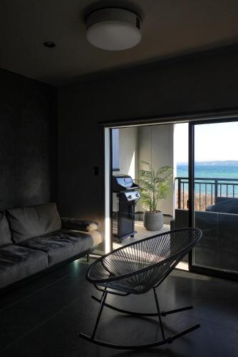a living room with a couch and a glass table at PrivateVilla8 in Minamiawaji