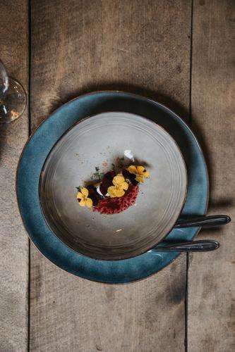 a plate with flowers on a wooden table at Knutes pensionat in Svansele