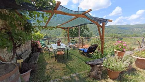 a patio with a table and chairs under a pergola at Agriturismo Podere Tegline in Radda in Chianti