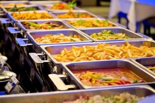 a buffet with many trays of food and french fries at Arobab desert safaris in Ajman 