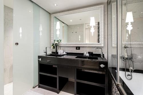 a bathroom with a sink and a mirror at Hotel Colón Gran Meliá - The Leading Hotels of the World in Seville