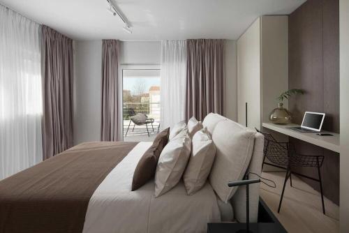 a bedroom with a bed and a desk with a laptop at Villa Georgiana in Funtana