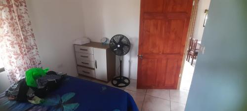 a bedroom with a bed and a fan next to a door at Casa a solo 20 minutos aproximadamente de Manuel Antonio Beach y a 10 minutos aproximadamente del centro de Quepos in Quepos