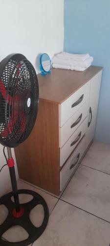a desk with a fan in front of a cabinet at Casa a solo 20 minutos aproximadamente de Manuel Antonio Beach y a 10 minutos aproximadamente del centro de Quepos in Quepos