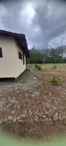 a small white building sitting on top of a field at Casa a solo 20 minutos aproximadamente de Manuel Antonio Beach y a 10 minutos aproximadamente del centro de Quepos in Quepos