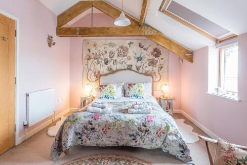 a bedroom with a large bed with a floral bedspread at Ocean View, Lowestoft in Lowestoft