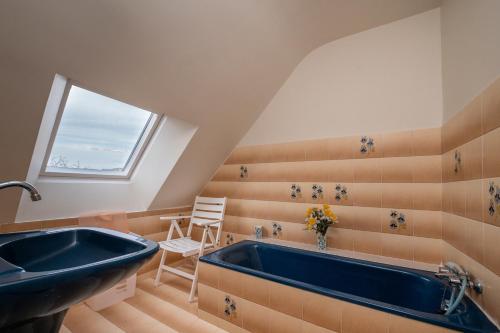 ein Badezimmer mit einem blauen Waschbecken und einem Fenster in der Unterkunft Maison Guidel plage - Vue mer in Guidel