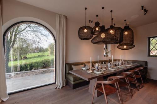 a dining room with a table and a large window at Le Temps de Vivre Chimay - Ardennen in Momignies
