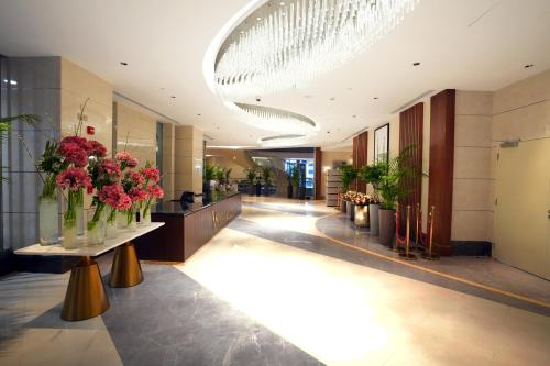 a lobby with flowers in vases on a table at Peninsula Worth Hotel in Al Madinah