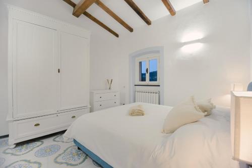 una camera bianca con letto e cassettiera di Anciüetta a Lerici