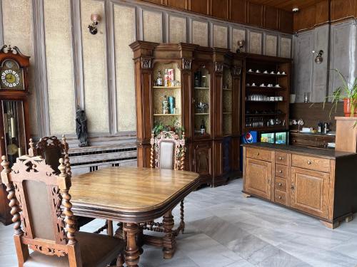 a dining room with a wooden table and a clock at Park Hotel Ivailo in Veliko Tŭrnovo