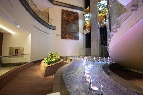 a museum with a long hallway with candles and plants at Peninsula Worth Hotel in Al Madinah