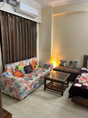 a living room with a couch and a coffee table at Elite Heaven Retreat 1 BHK Budget Home Stay Tapovan in Tapovan