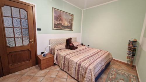 a teddy bear sitting on a bed in a bedroom at Civico3 in Ovada