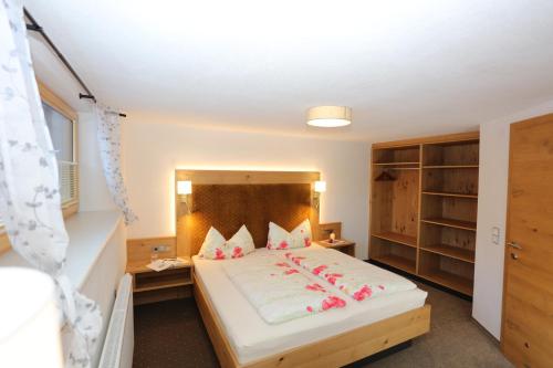a bedroom with a bed with pink flowers on it at SennHOF Lechtal in Bach