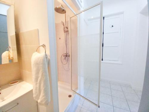 une salle de bain avec une douche avec une porte vitrée dans l'établissement Palais Alexandre, à Cannes