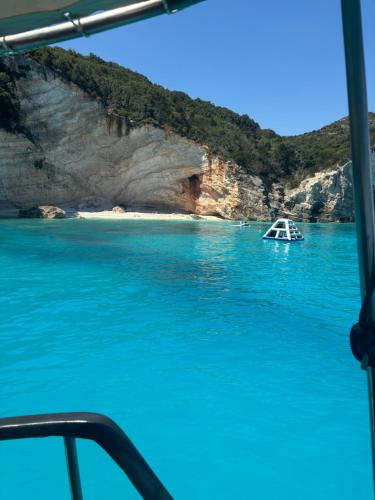 a boat in the water next to a beach at Poseidon boat trips in Svoronata