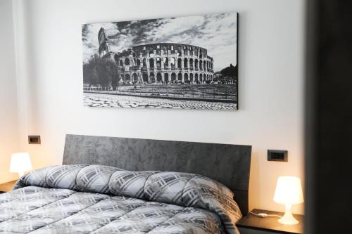 a bedroom with a bed and a picture of a building at Roby's House 70 in Settebagni