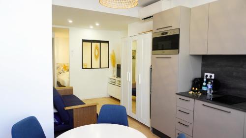 - une cuisine avec une table et des chaises bleues dans la chambre dans l'établissement Proche Carlton & Croisette, Appartement 302 - Palmazur Vacances, à Cannes