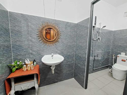 a bathroom with a sink and a toilet and a mirror at GOLDEN LOTUS SPA & HOMESTAY in Ấp Thiện Phước