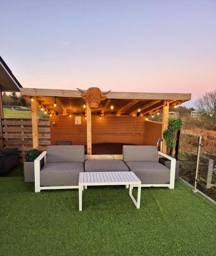 a gazebo with two couches and a table at Top Lodge in Newton Stewart