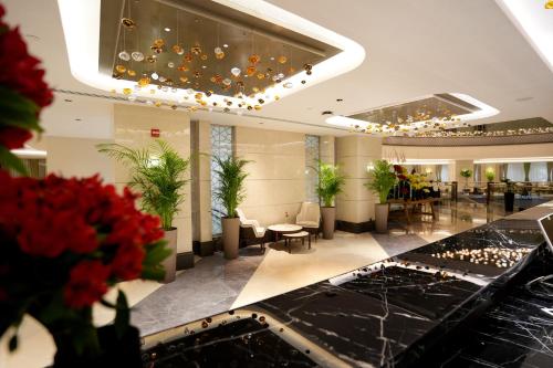 a lobby of a hotel with tables and chairs at Peninsula Worth Hotel in Al Madinah
