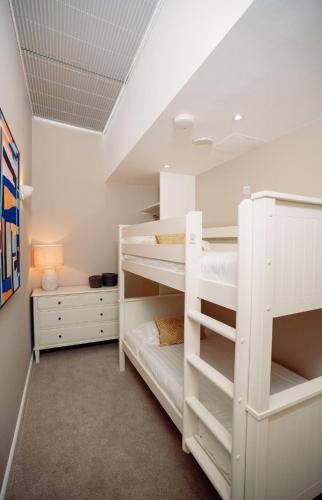 a room with two bunk beds and a desk at Les Ormes Resort in St Brelade