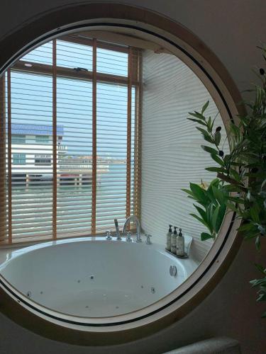 a bathroom with a large tub in front of a window at Moonlight Kohlarn in Ko Larn