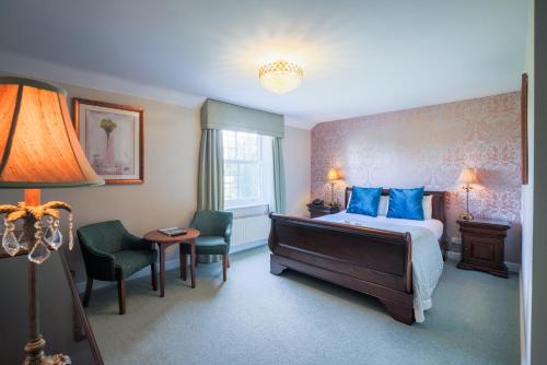 a hotel room with a bed and a table and chairs at Stallingborough Grange Hotel in Stallingborough