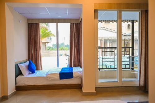 Un dormitorio con una cama y una ventana grande. en Hotel M Plaza Mandarmani, en Mandarmani