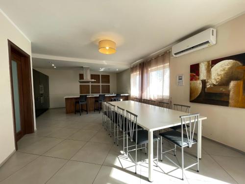 a dining room with a white table and chairs at Villa Diamantina in St Julian's