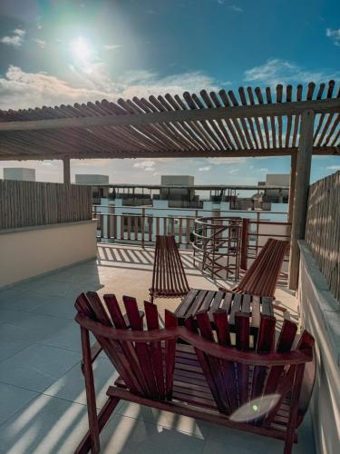 a balcony with two chairs and a pergola at Quality - Boas Vistas in Canoa Quebrada