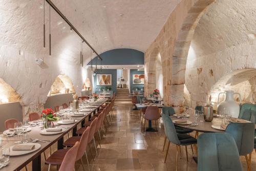 a dining room with long tables and chairs at Palazzo Indelli in Monopoli