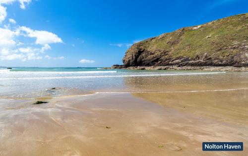 una playa de arena con el océano al fondo en Pelcomb Cross Farmhouse, en Haverfordwest
