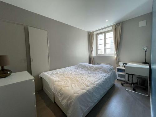 une chambre avec un lit, un bureau et une fenêtre dans l'établissement Appartement T2 à La Rochelle - LR180-002, à La Rochelle