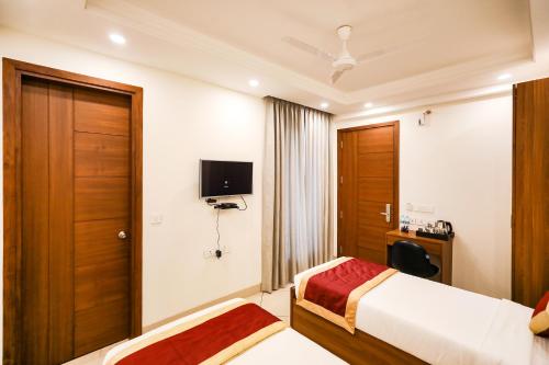 a hotel room with a bed and a tv at FabHotel La Paz Stay B&B in New Delhi