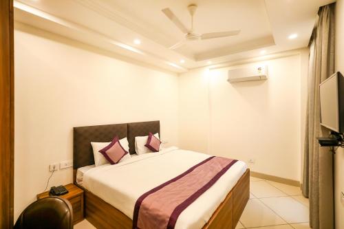 a bedroom with a large bed with pink pillows at FabHotel La Paz Stay B&B in New Delhi