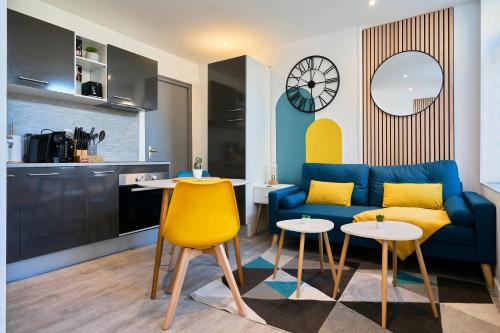 un salon avec un canapé bleu et un fauteuil jaune dans l'établissement Le Brother - Les Demeures d 'Adrien, à Carvin